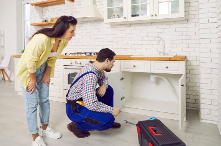 Profissional arrumando uma pia de cozinha entupida