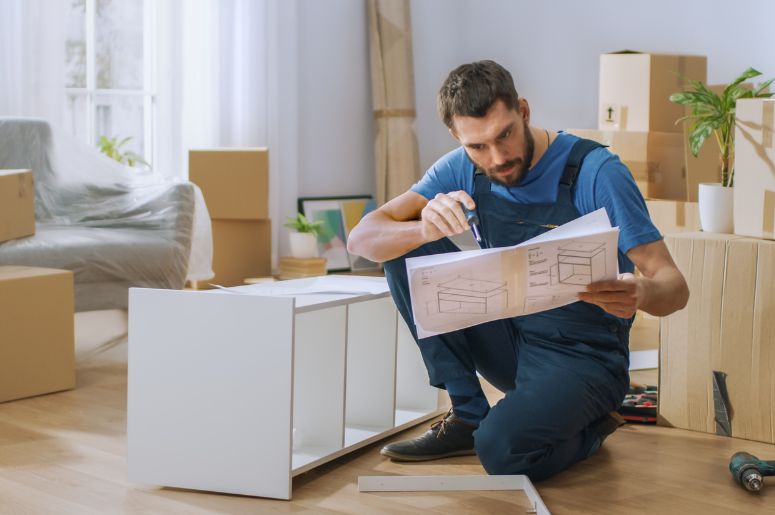 Homem vendo manual para montar móveis