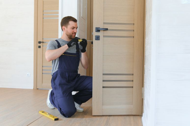 Homem instalando porta de madeira
