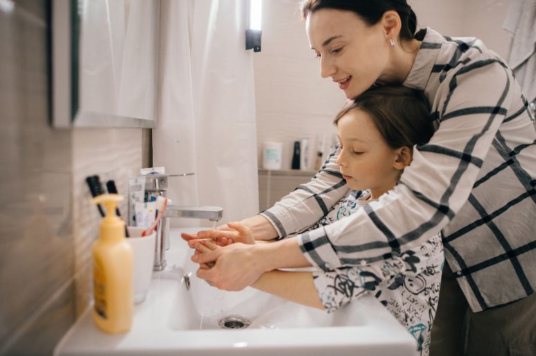 Mãe e Filho lavando as mãos no banheiro
