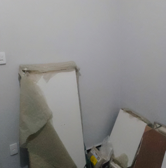Desmontagem de móveis em quarto, com peças organizadas para transporte