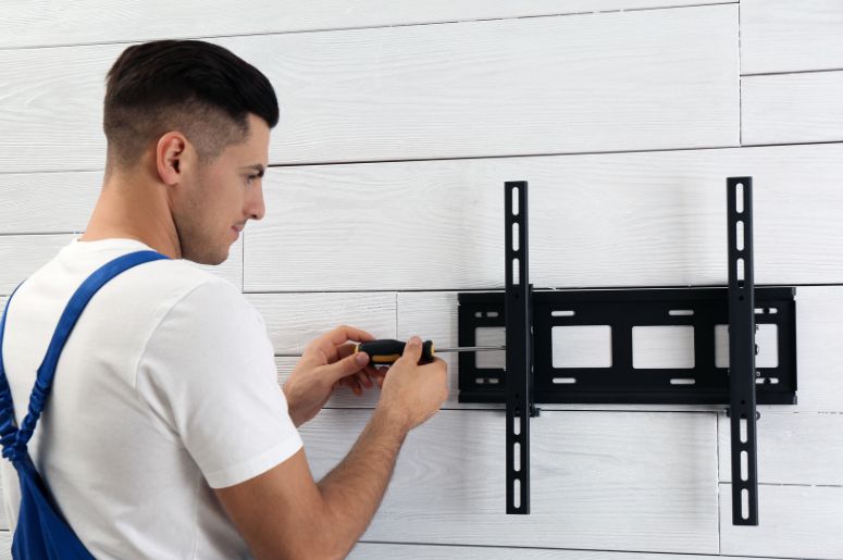 Homem instalando suporte de tv