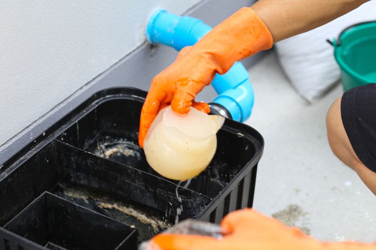 Homem limpando caixa de gordura