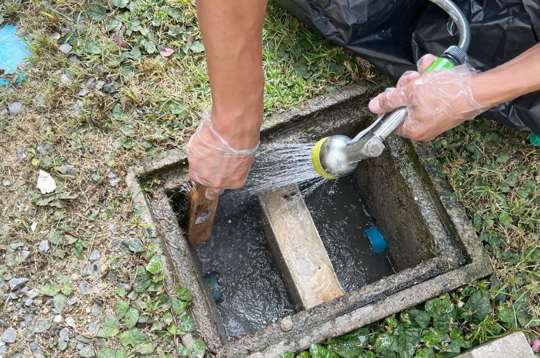 Homem fazendo manutenção em uma caixa de gordura