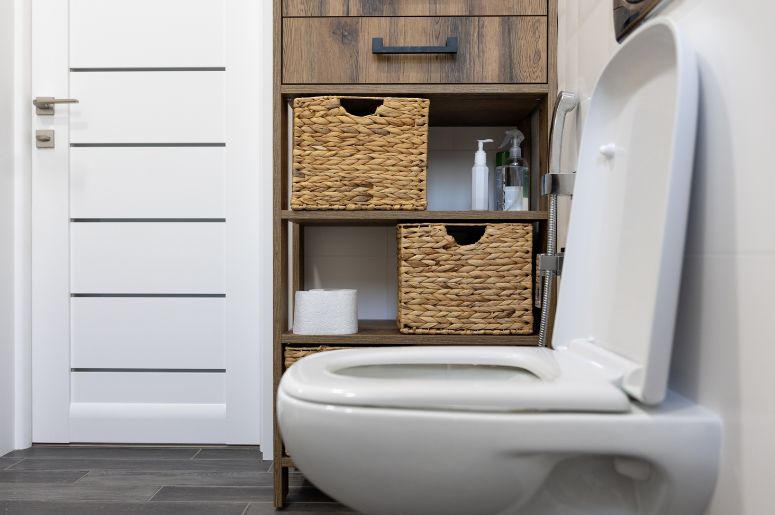 vaso sanitário branco em banheiro com estante 