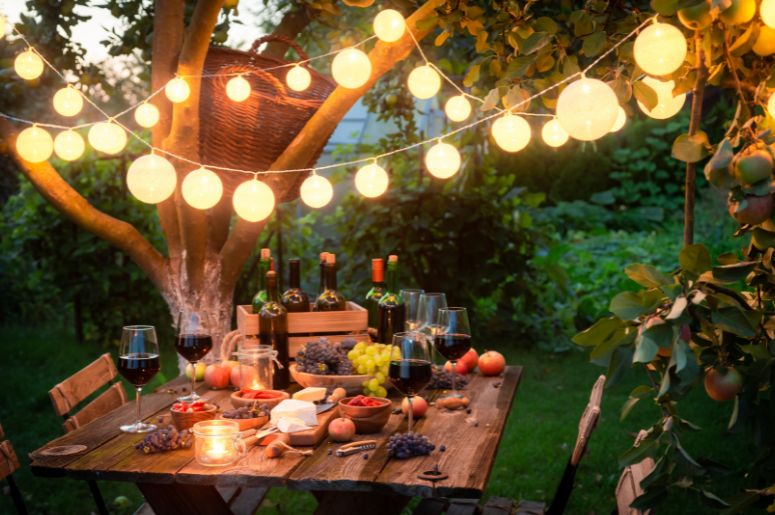Jardim com luzes e mesa com comidas