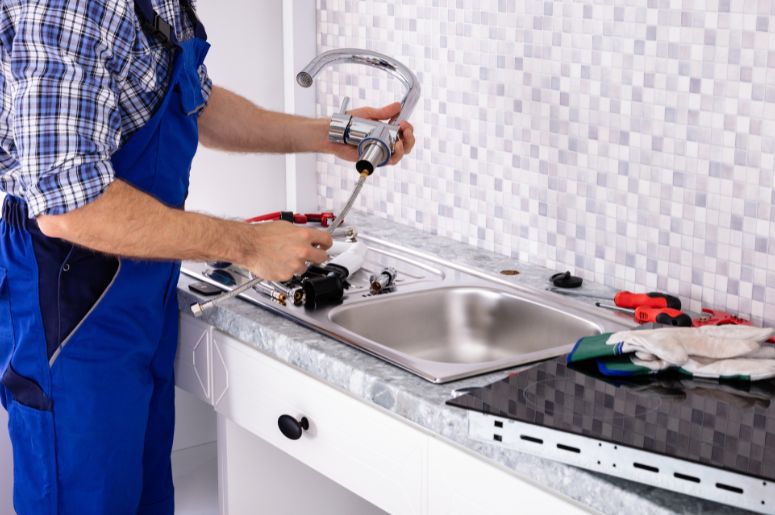 Homem instalando torneira