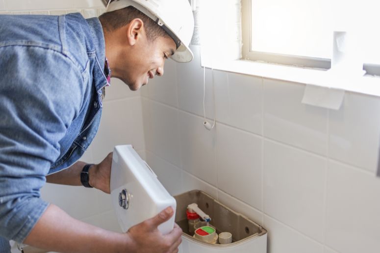 Encanador instalando vaso sanit&aacute;rio com caixa acoplada 
