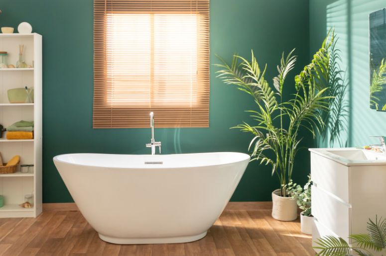 Banheiro com parede verde e decorado com plantas