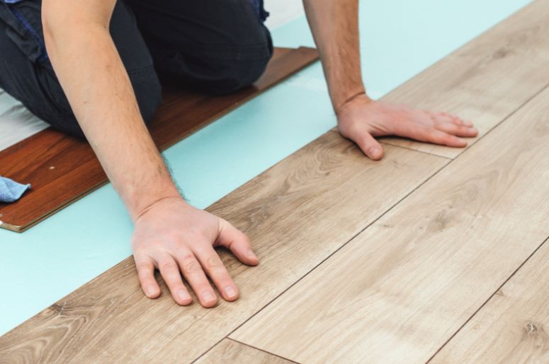 Homem instalando piso de madeira