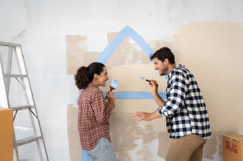 Casal pintando parede de casa