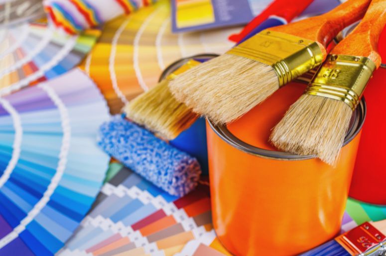 Lata de tinta laranja e pastas com cores de tinta 