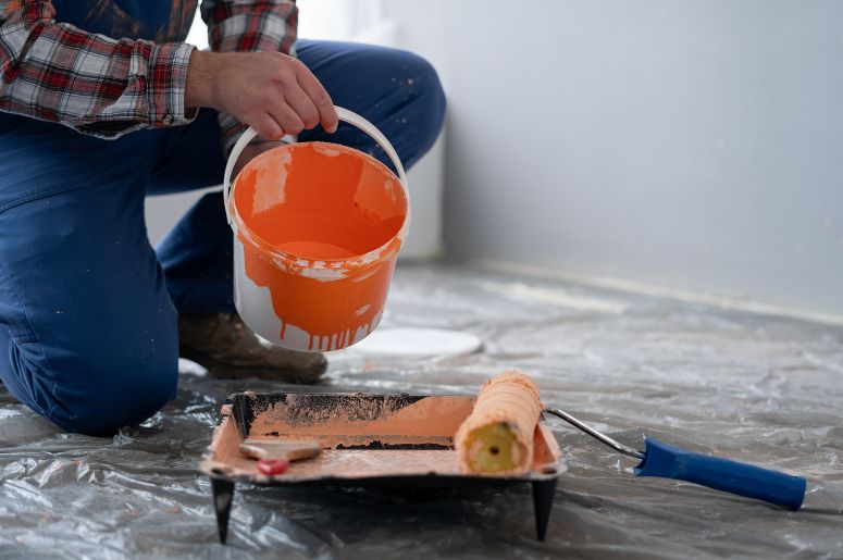 Homem preparando tinta laranja 