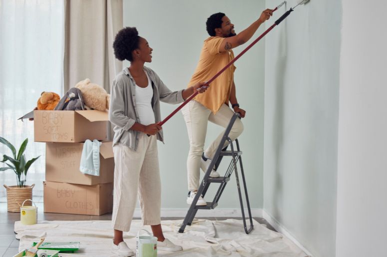 Casal pintando o centro da parede