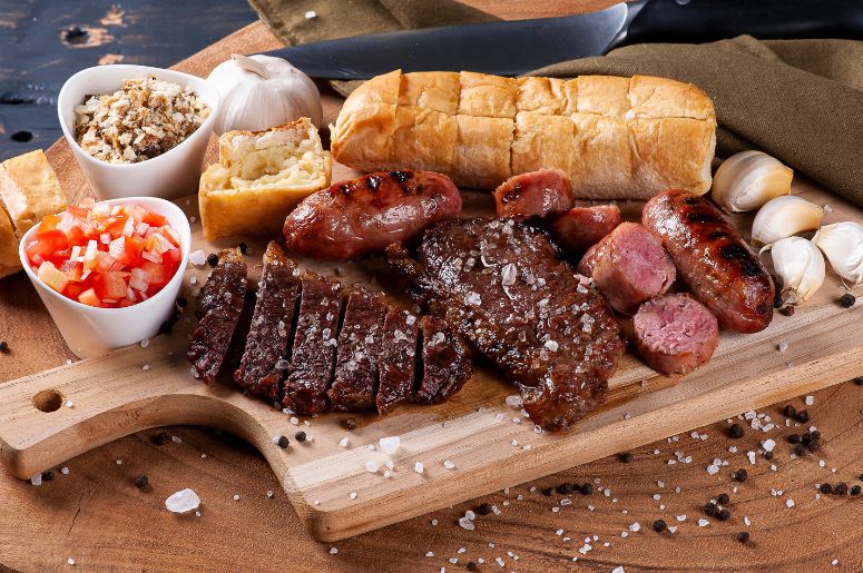 Prato de churrasco com lingui&ccedil;a, vinagrete, p&atilde;o de alho, farofa e carne