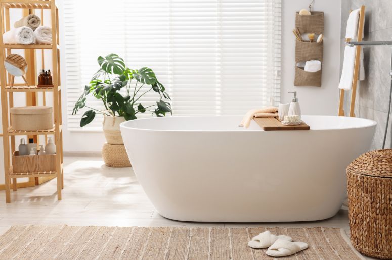 Banheiro com banheira branca e plantas na decoração