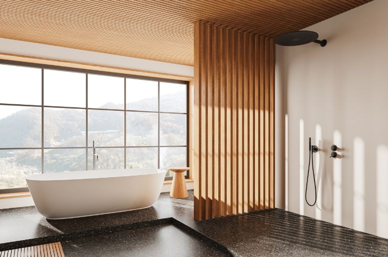 Banheiro com piso preto e banheira branca