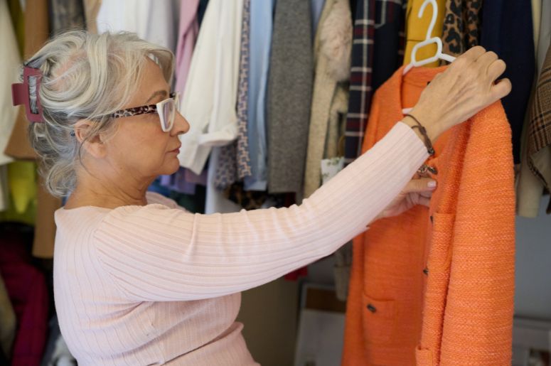 Idosa escolhendo roupas do guarda-roupa