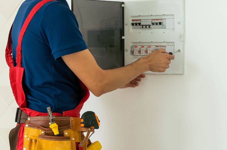 Homem instalando quadro de distribui&ccedil;&atilde;o