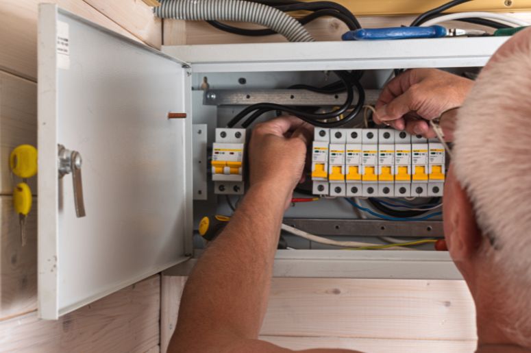 Pessoa instalando quadro de Distribui&ccedil;&atilde;o