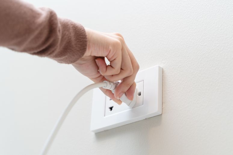  Pessoa colocando eletr&ocirc;nico na tomada