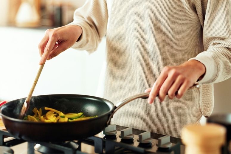 Pessoa cozinhando em cooktop