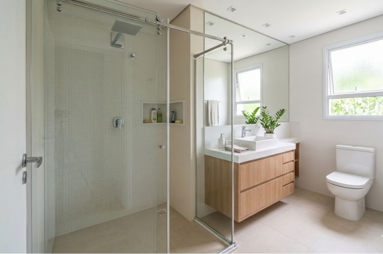 Banheiro pequeno com box e gabinete de madeira