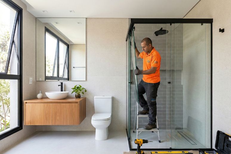 Homem instalando box em banheiro