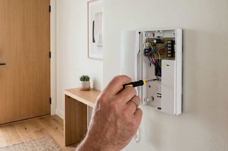 Homem consertando interfone de apartamento