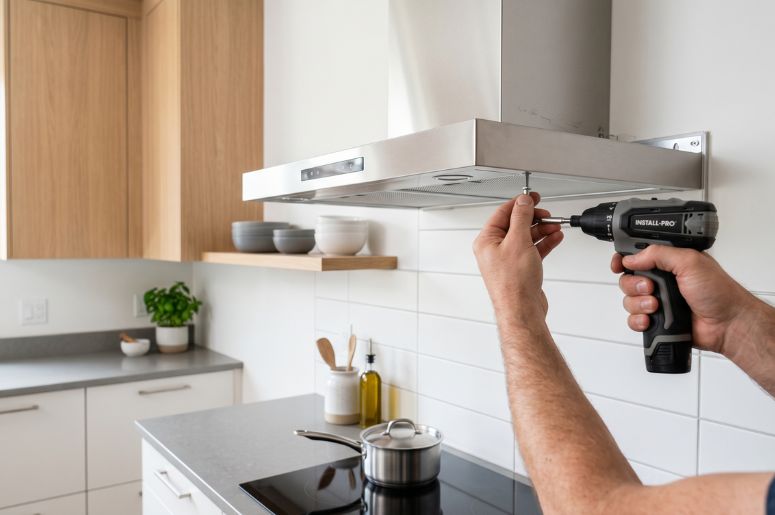 Homem instalando coifa em cozinha