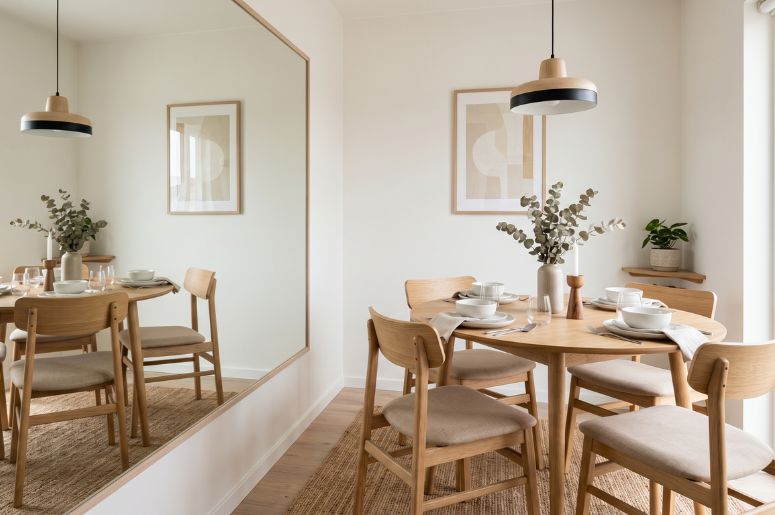 Sala de jantar com espelho gande e mesa de madeira
