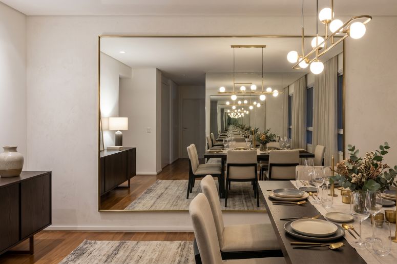 Sala de jantar com espelho retangular na parede e decora&ccedil;&atilde;o moderna
