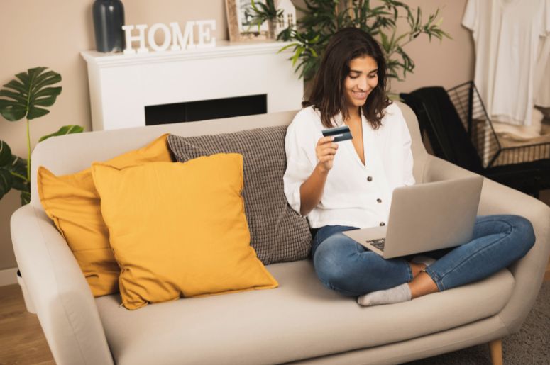 Mulher usando notebook e cartão para comprar online