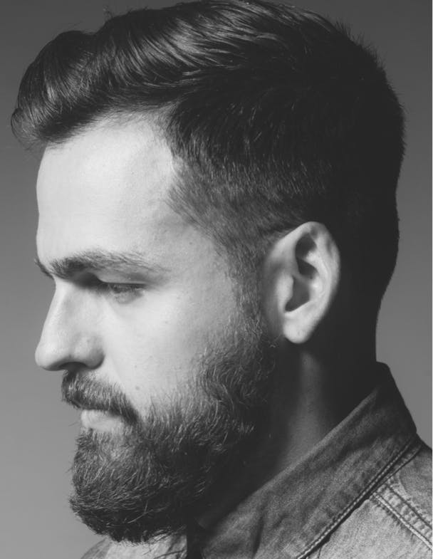 Black and white profile picture of a man with a beard.