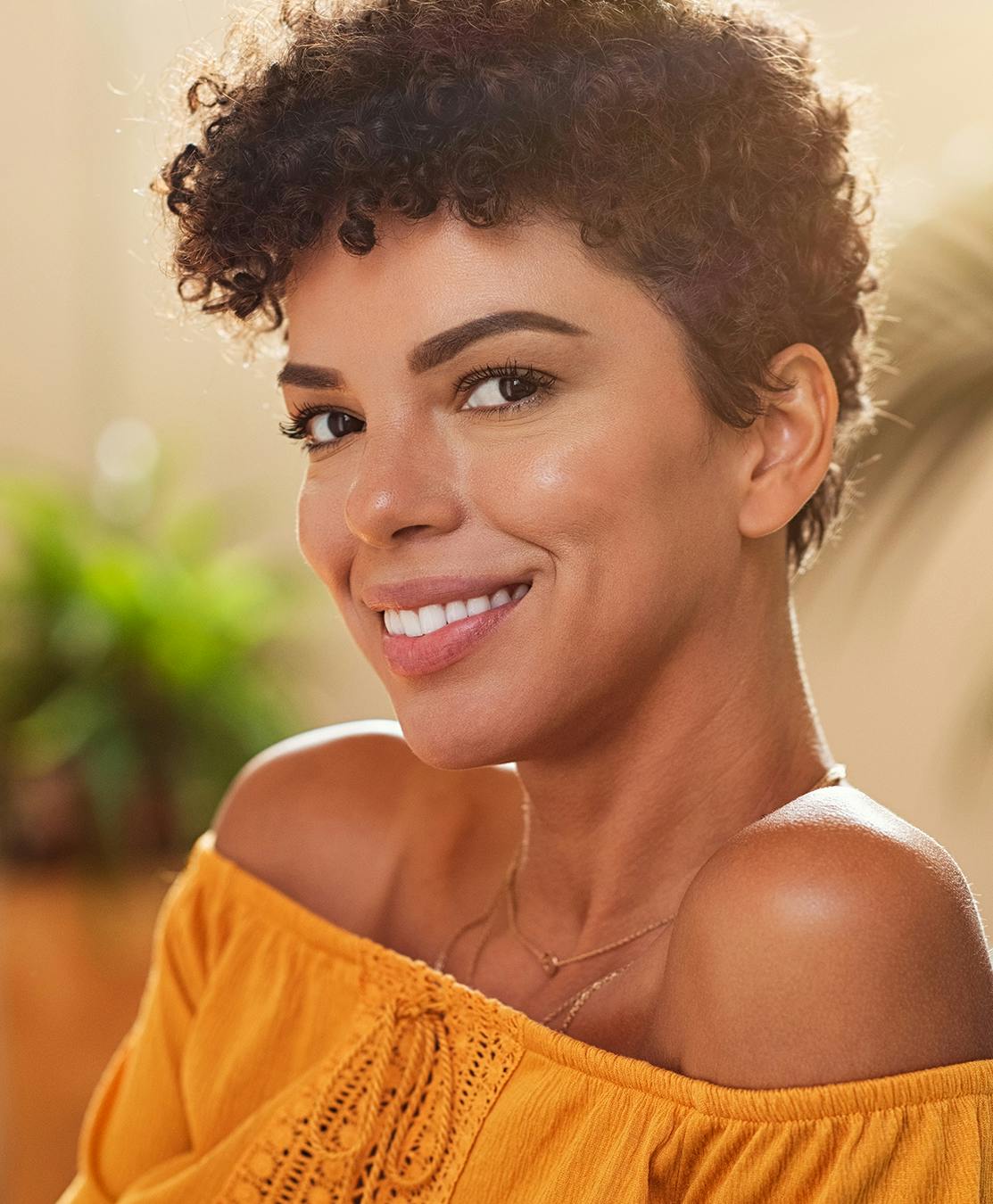 Woman in sleeveless yellow top smiling