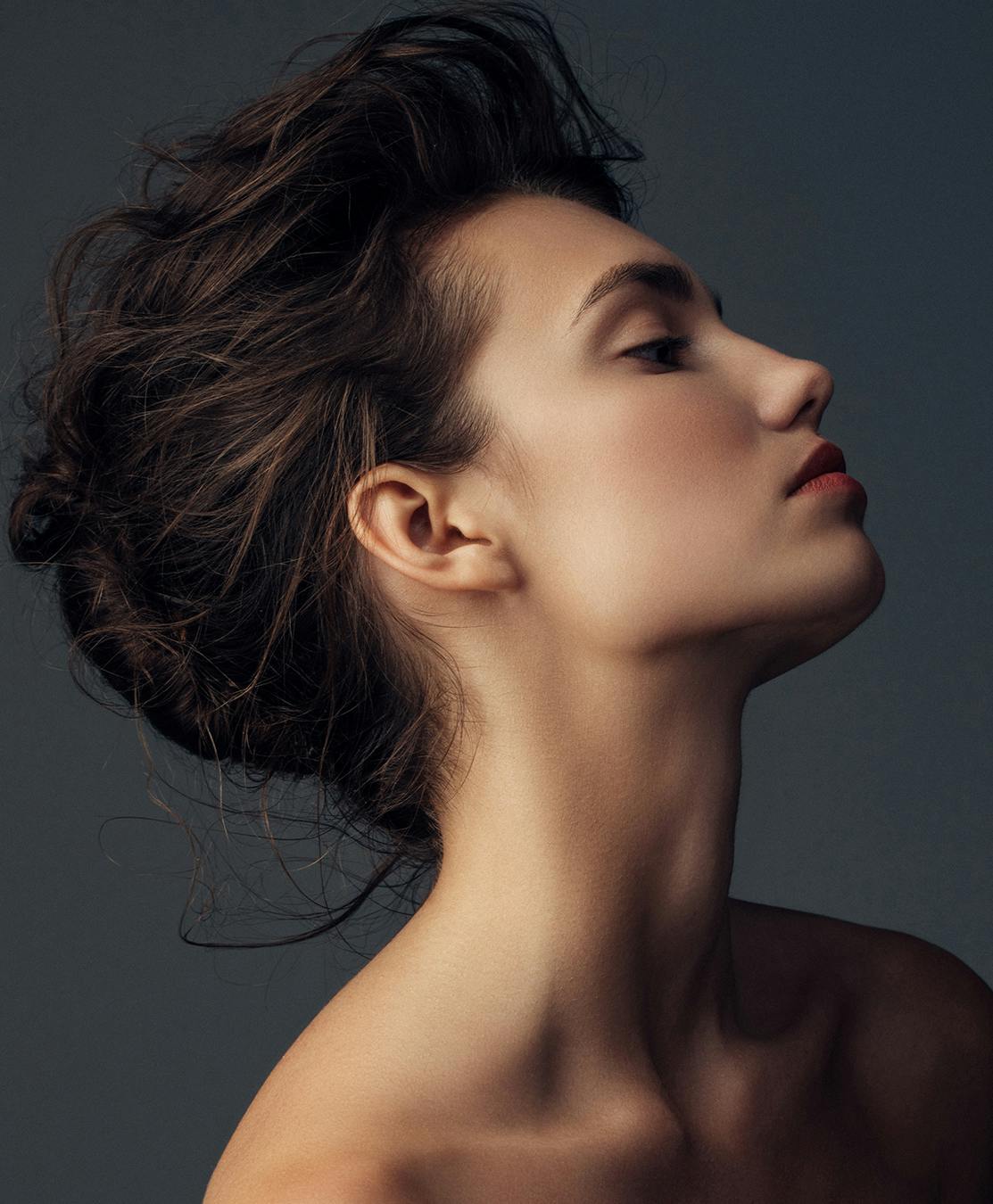 Profile of a woman's face with dark background.