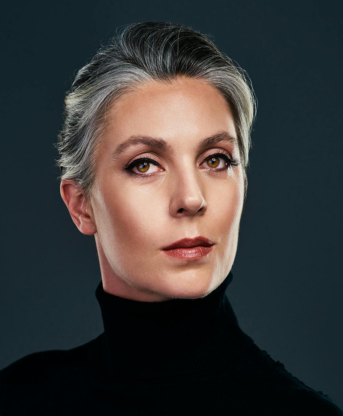 Grey haired woman posing for the camera.