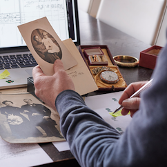 Man looking at historical sepia tone photograph