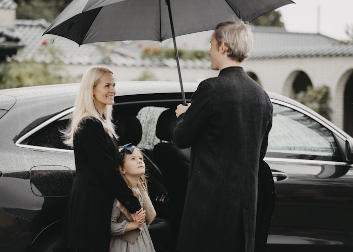 Familie ved bil i regnvejr