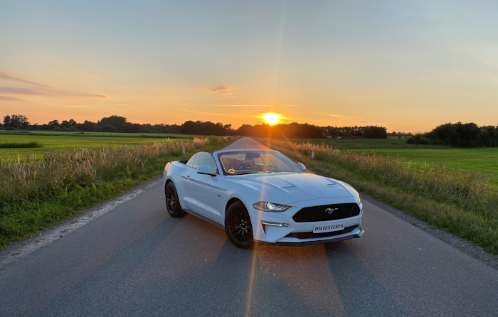 Hvid Ford Mustang i solnedgang