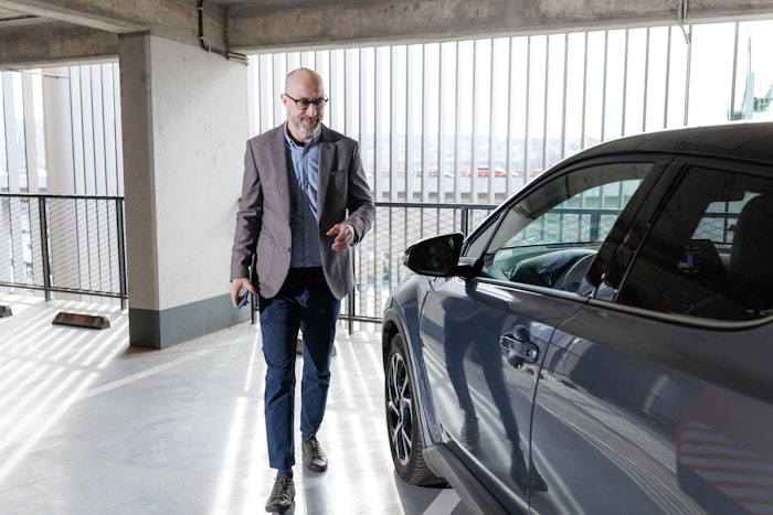 Mand ved bil i parkeringshus