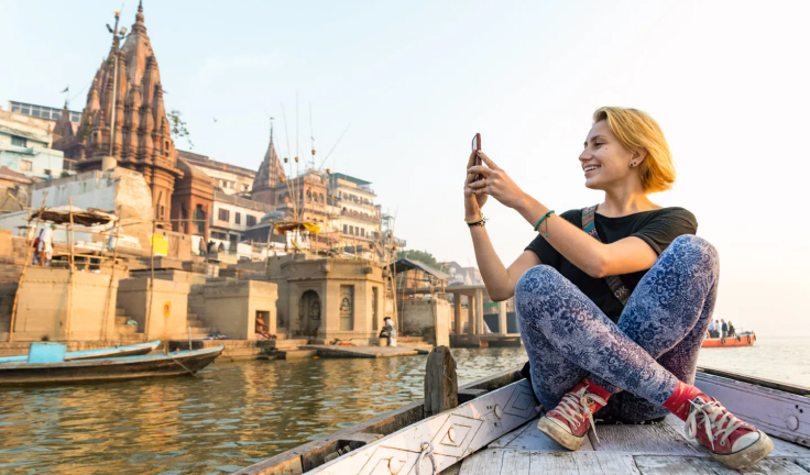 A woman on a boat on a river taking a photo