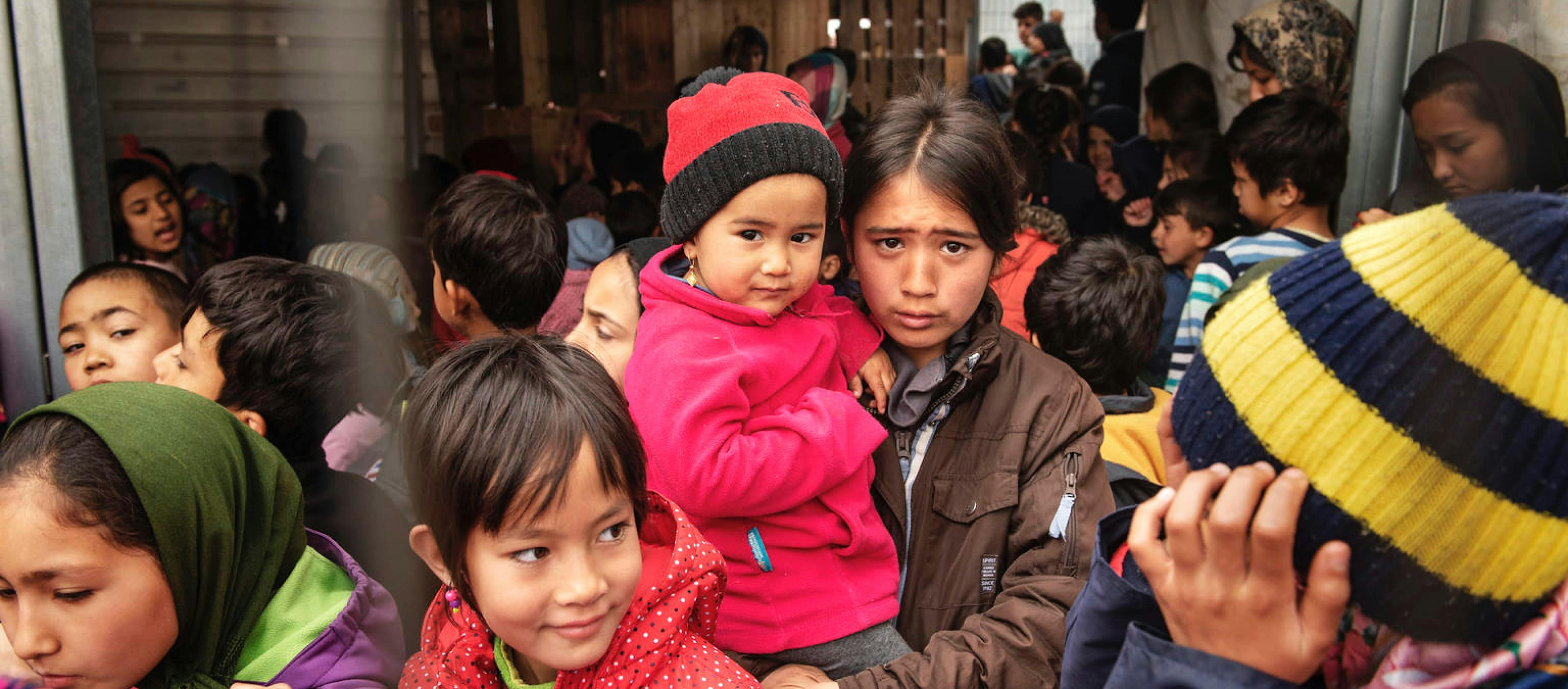 Bambini migranti in fila per un succo di frutta sull’isola di Lesbo, in Grecia.