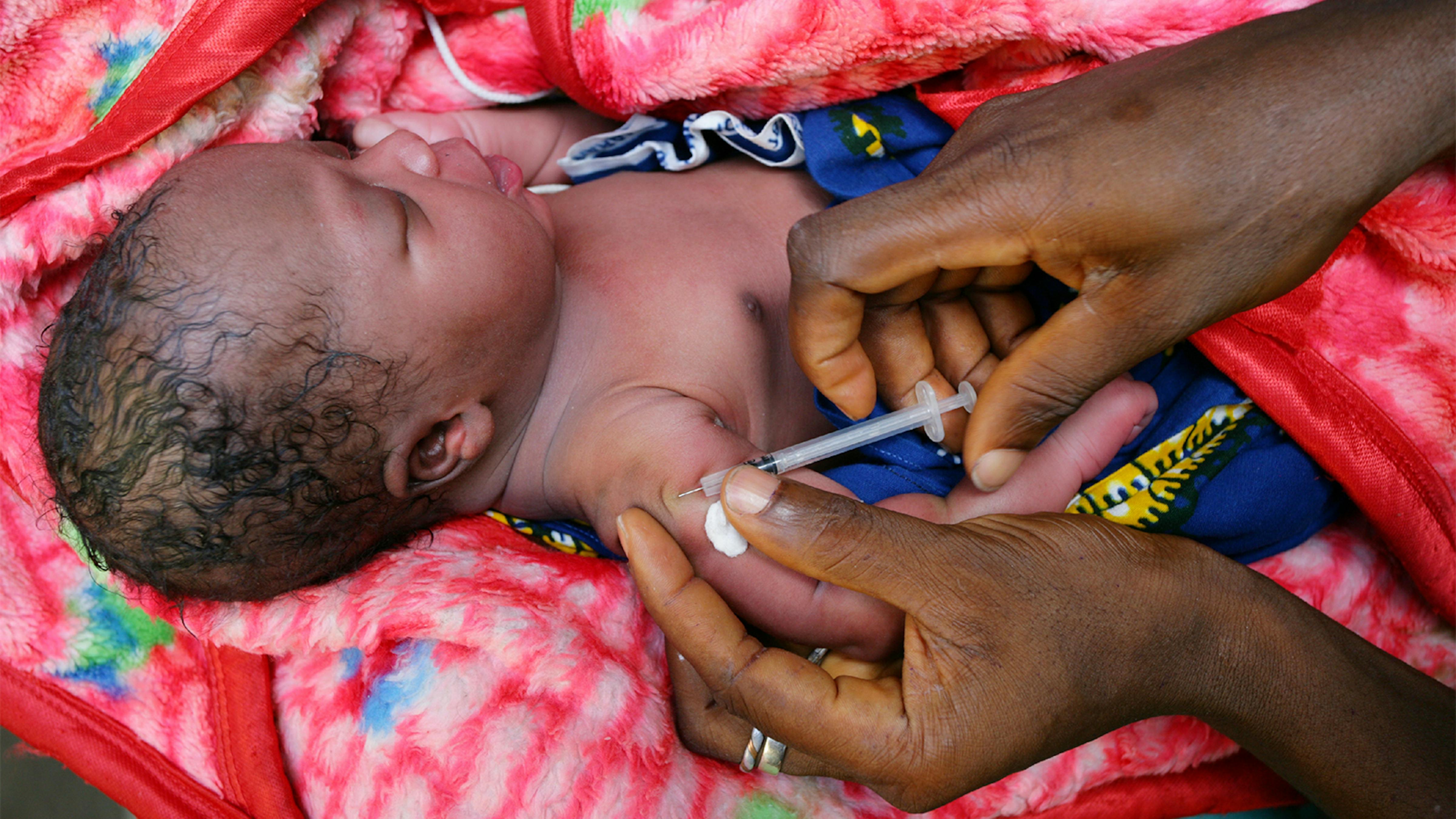 Liberia, un operatore sanitario vaccina un neonato al Redemption Hospital di Monrovia