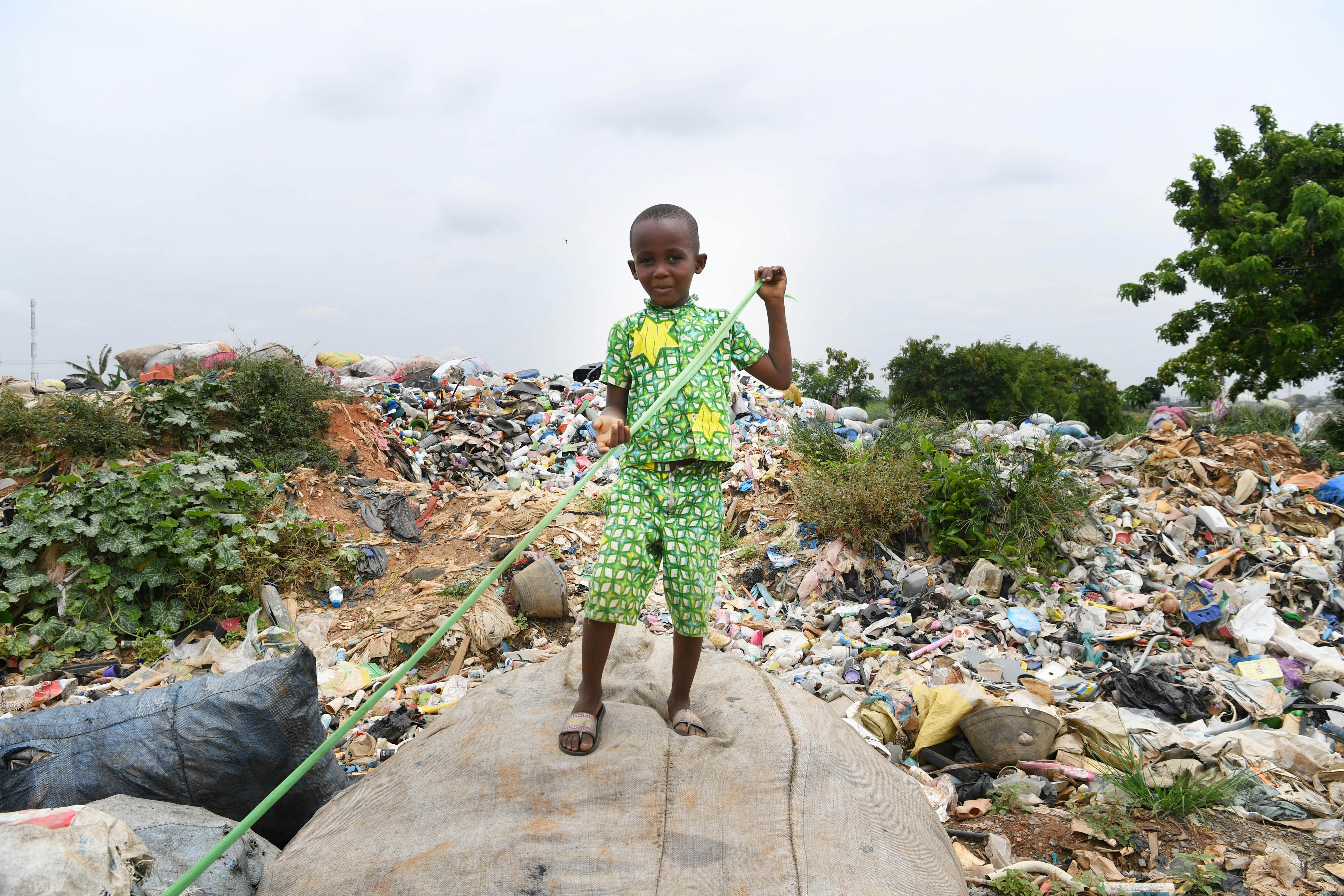 Un bambino gioca in una discarica ad Abidjan, in Costa d'Avorio.