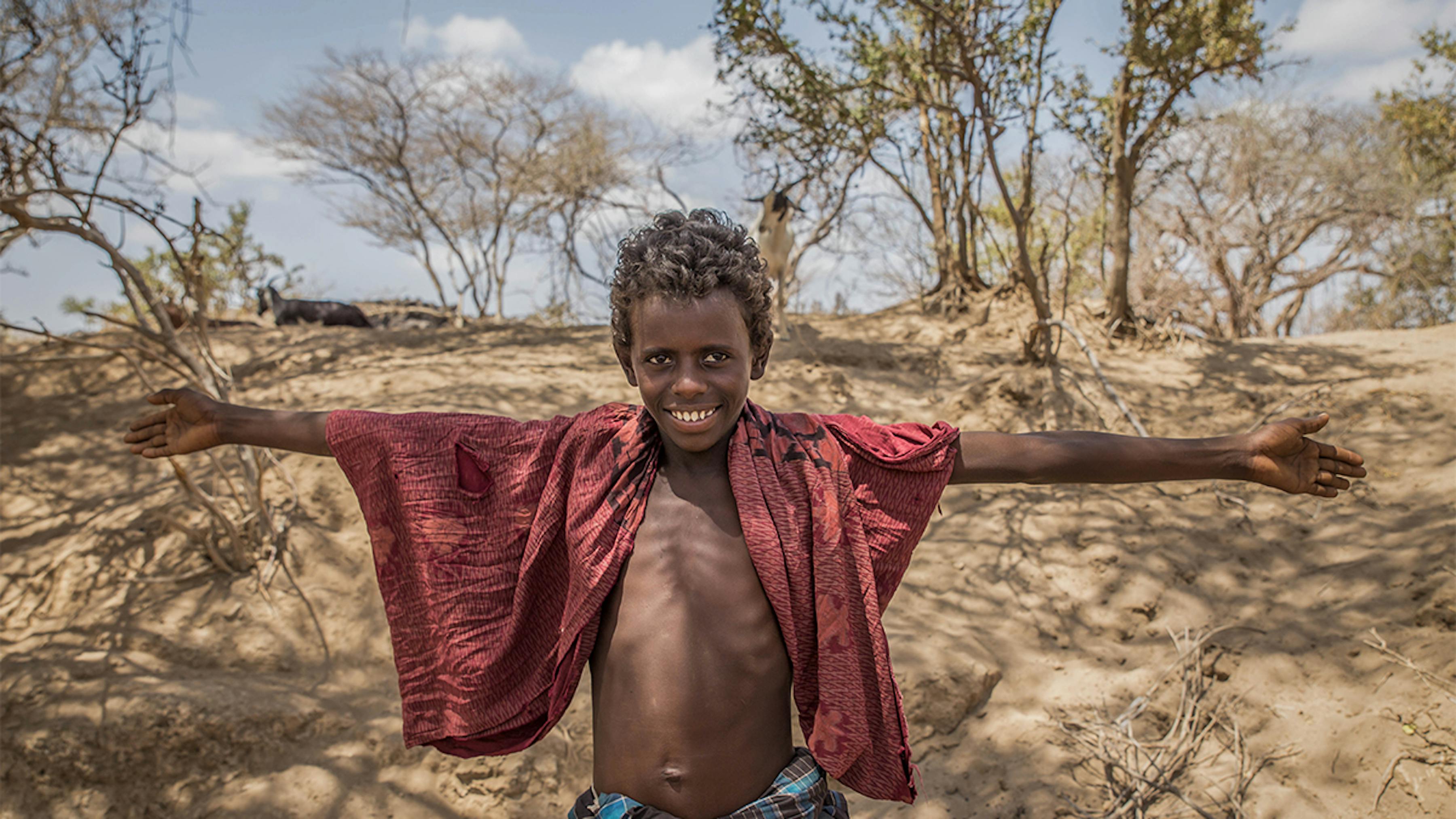 2016 Etiopia. Un bambino posa davanti al terreno della sua famiglia arido a causa della siccità