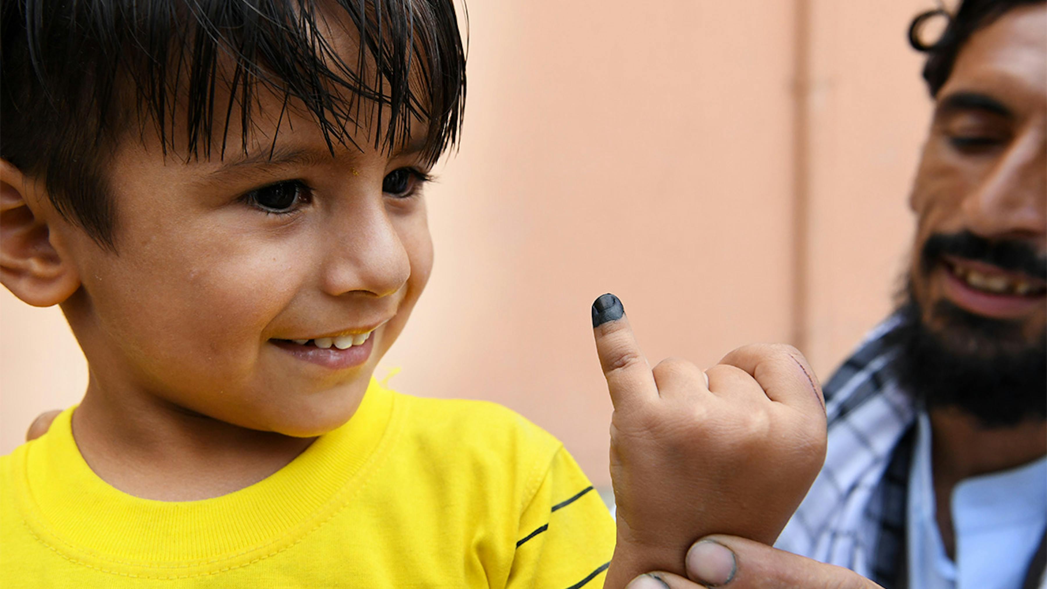 Afghanistan, un bambino mostra il dito segnato, è stato appena vaccinato contro la polio