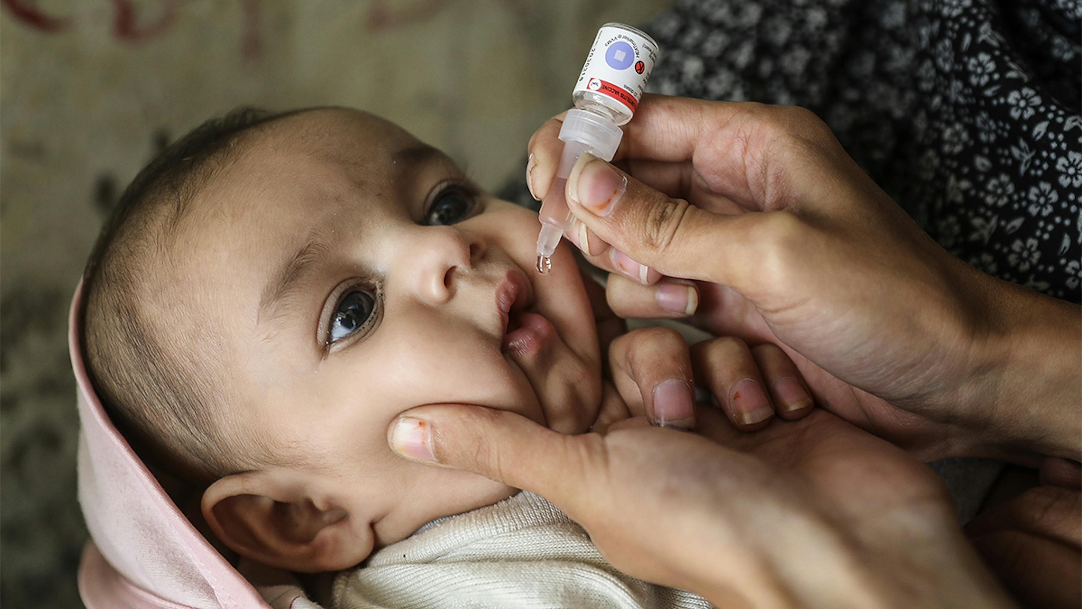 Pakistan, un operatore sanitario vaccina Sajjad Ali (3 mesi) contro la poliomielite