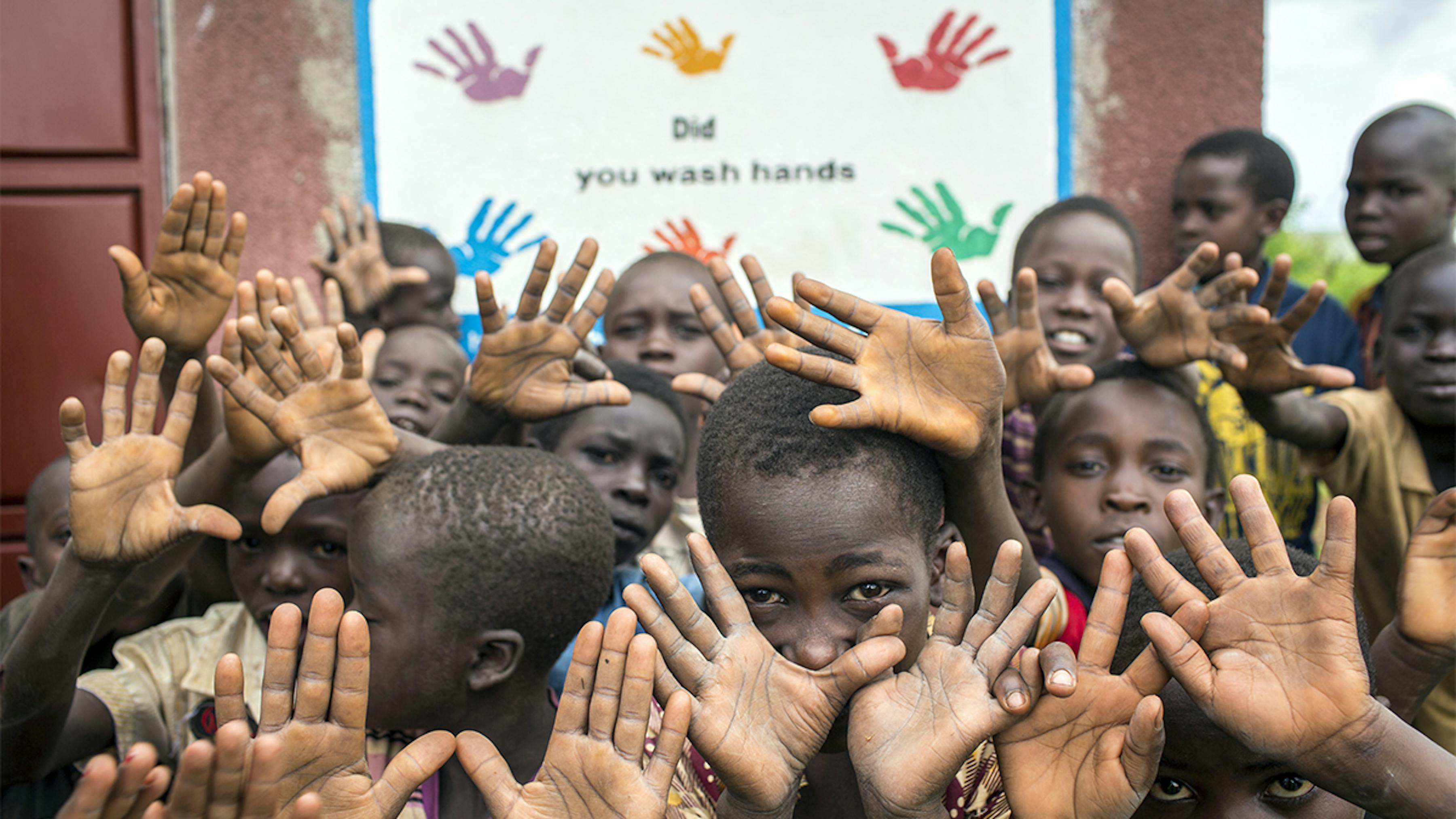 Uganda, studenti di fronte a un cartello che promuove il lavaggio delle mani a scuola