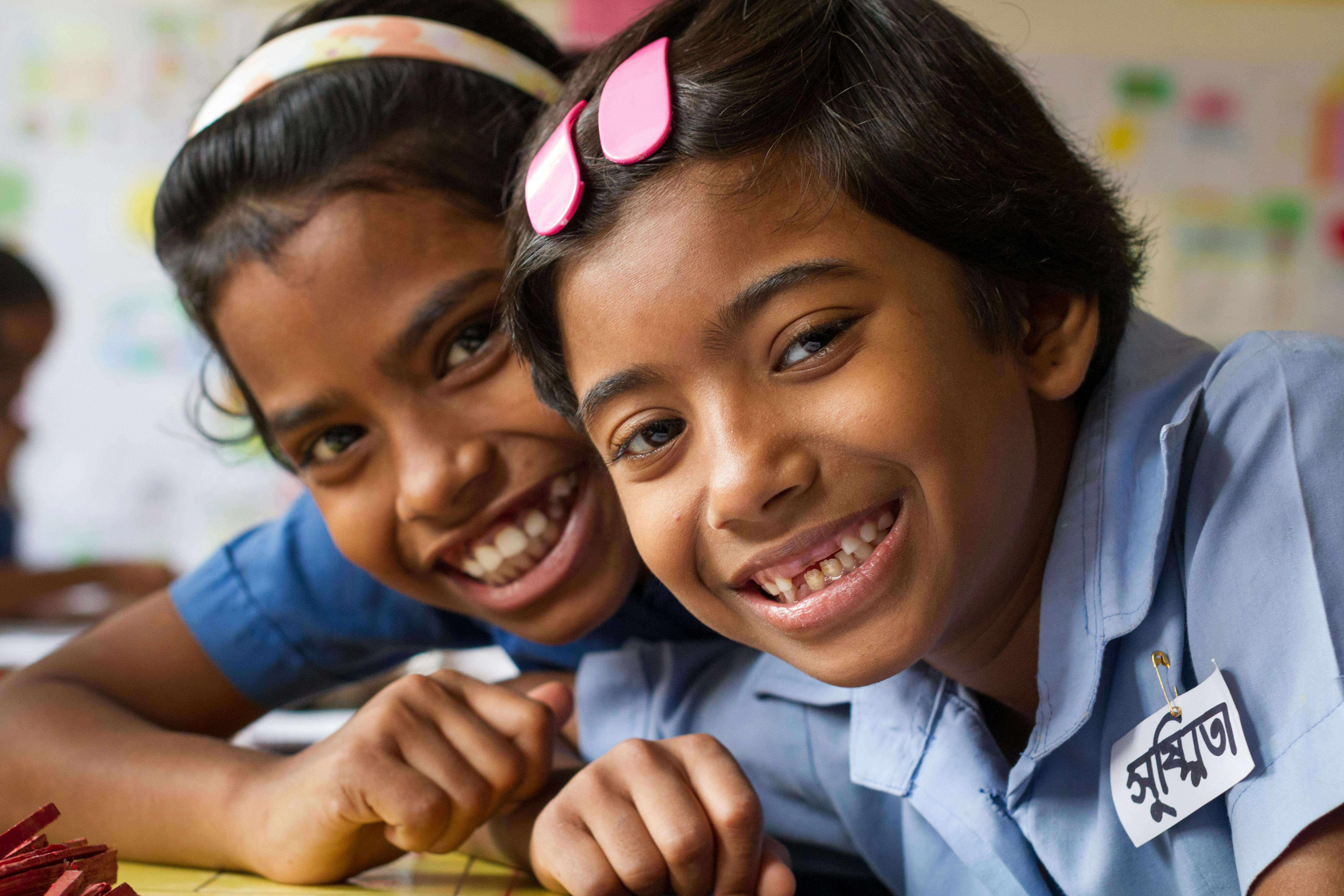 Shushmita e la sua amica Binky sorridono mentre sono a scuola, in Bangladesh.